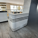 Comptoir d’accueil blanc brillant & bandes métalliques – design courbe haut de gamme